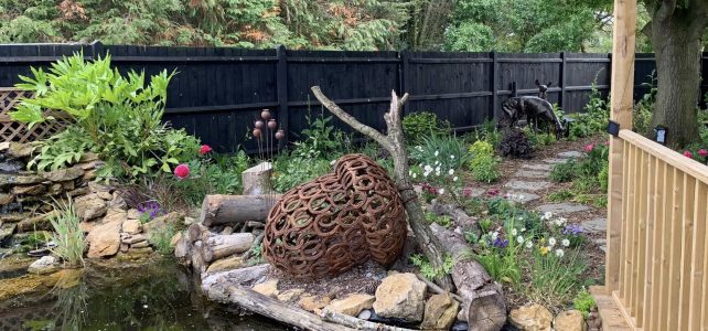 Horseshoe acorn sculpture sat by pond