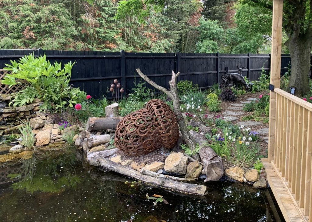 Metal acorn sculpture by pond