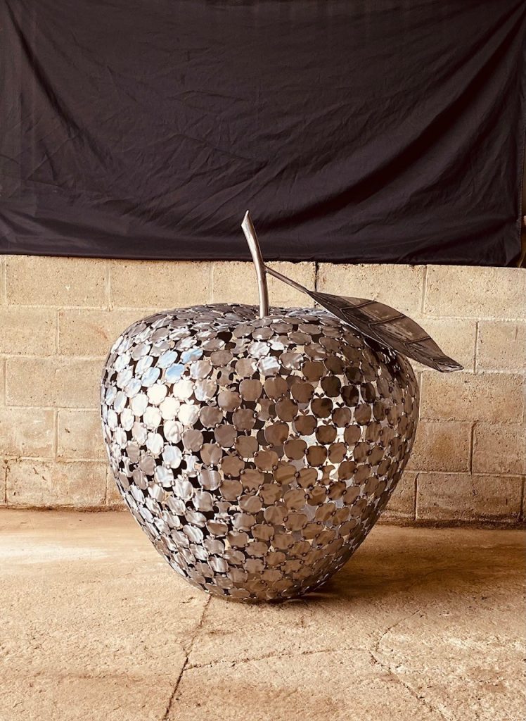 Apple of Apples sculpture on concrete background