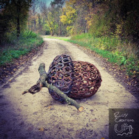Metal handmade acorn sculpture laying on country road in autumn